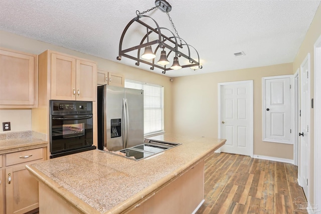 2724 Ashbury Ln, Cantonment, FL 32504 - kitchen featuring black oven, stainless steel fridge, light brown cabinetry, cooktop, and a textured ceiling