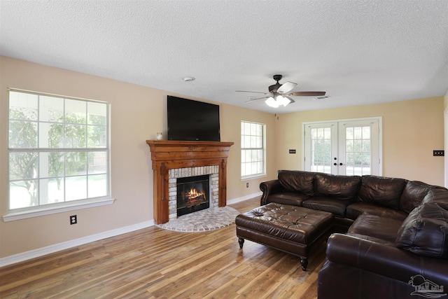 2724 Ashbury Ln, Cantonment, FL 32504 - living area featuring light wood-style flooring, a textured ceiling, ceiling fan, french doors, and a fireplace