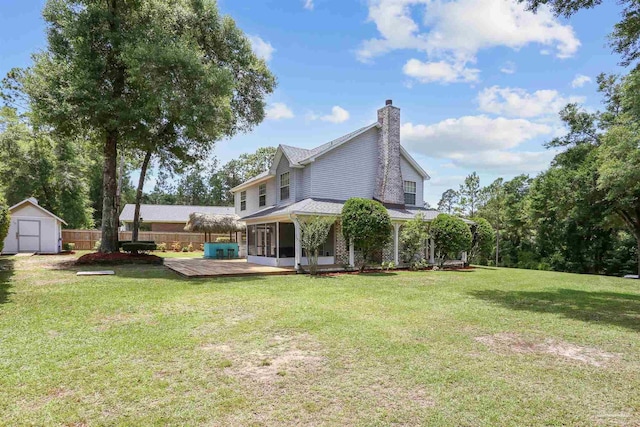 2724 Ashbury Ln, Cantonment, FL 32504 - back of house featuring a sunroom, a storage unit, a deck, and a chimney