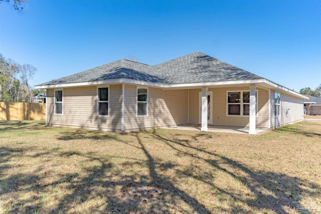 rear view of property with a patio and a lawn