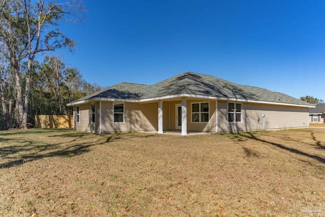 rear view of property with a patio and a lawn