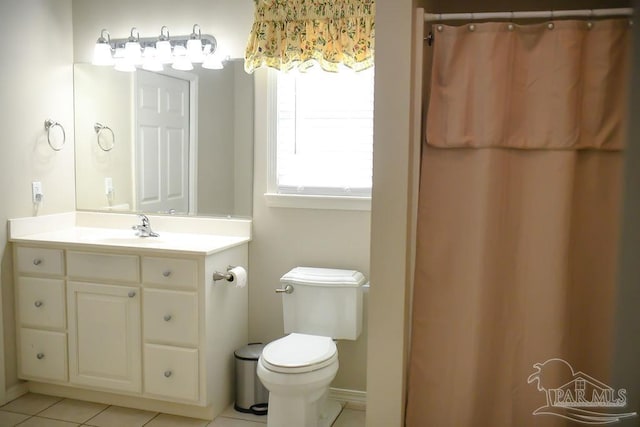 bathroom featuring toilet, vanity, tile patterned flooring, and walk in shower