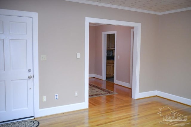 empty room with wood-type flooring and crown molding