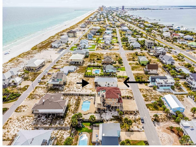 birds eye view of property featuring a water view and a beach view