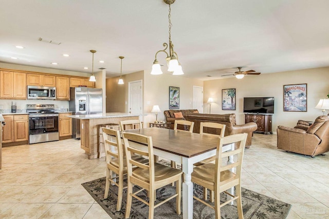 dining room with light tile patterned floors and ceiling fan with notable chandelier