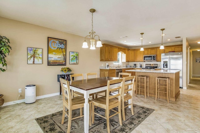 tiled dining space featuring sink and a notable chandelier