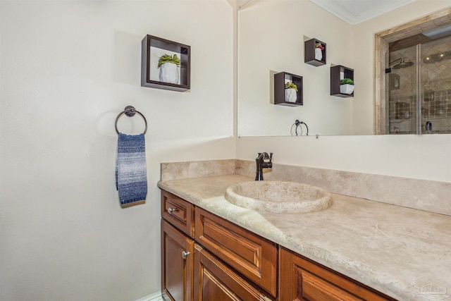 bathroom with ornamental molding, vanity, and a shower with shower door