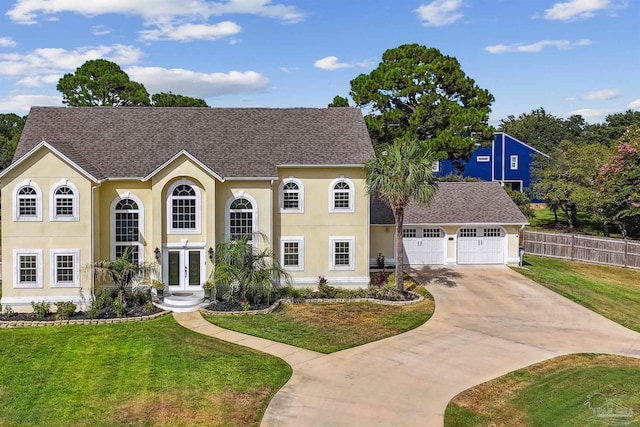 view of front of property featuring a garage, a front lawn, and french doors