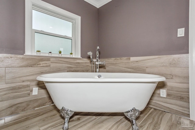 bathroom with crown molding, tile walls, and a tub