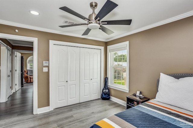 bedroom with crown molding, a closet, ceiling fan, and hardwood / wood-style flooring