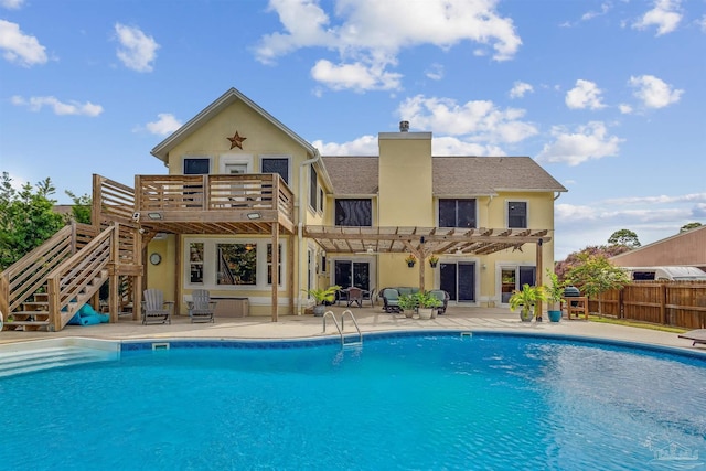 back of property with a fenced in pool, a patio, and a pergola