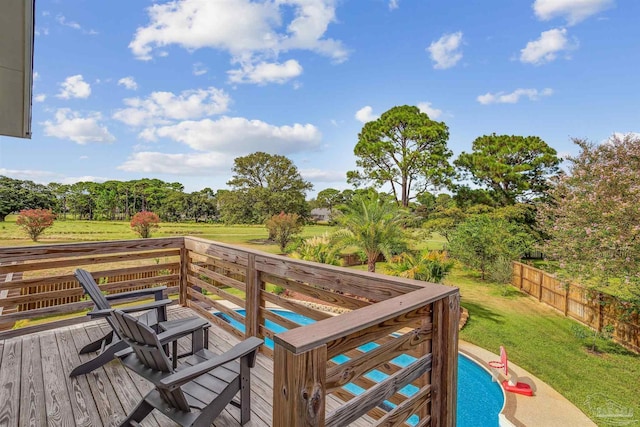 wooden deck featuring a fenced in pool and a lawn