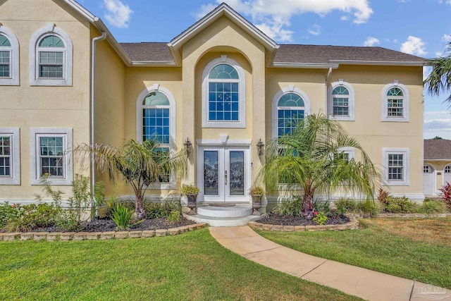 view of front of home featuring a front yard and french doors