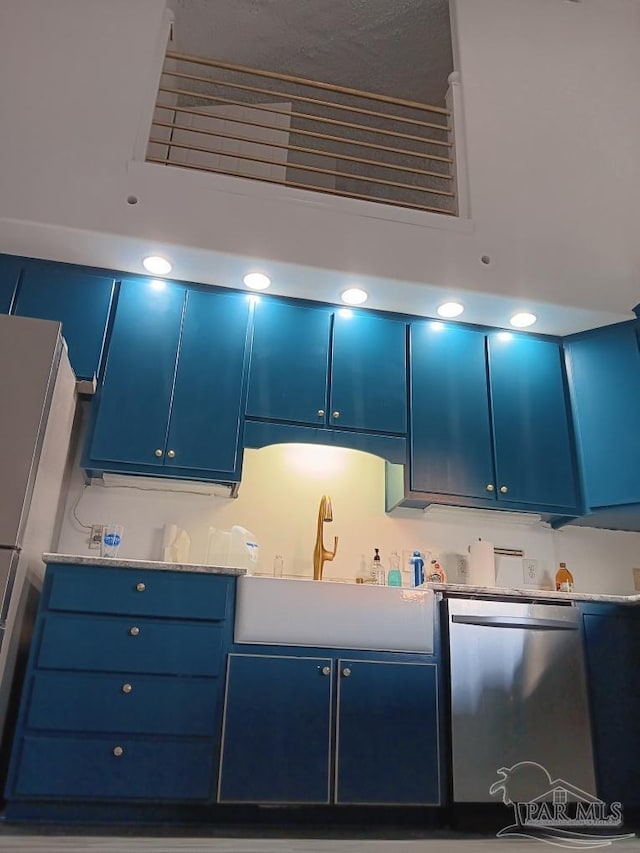 kitchen featuring blue cabinetry, dishwasher, and sink