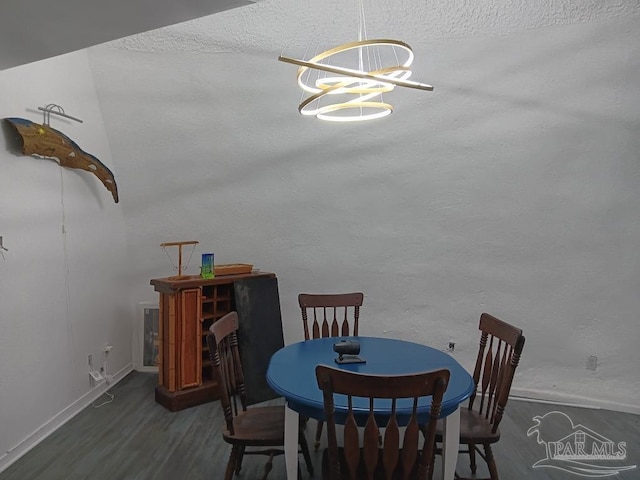 dining space with dark hardwood / wood-style flooring, a textured ceiling, and a chandelier