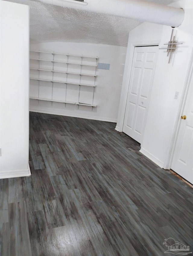 basement with dark hardwood / wood-style flooring and a textured ceiling