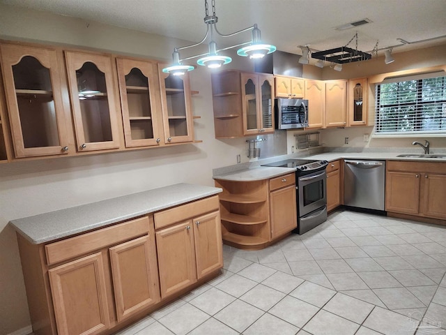 kitchen with light tile patterned flooring, sink, appliances with stainless steel finishes, an inviting chandelier, and decorative light fixtures