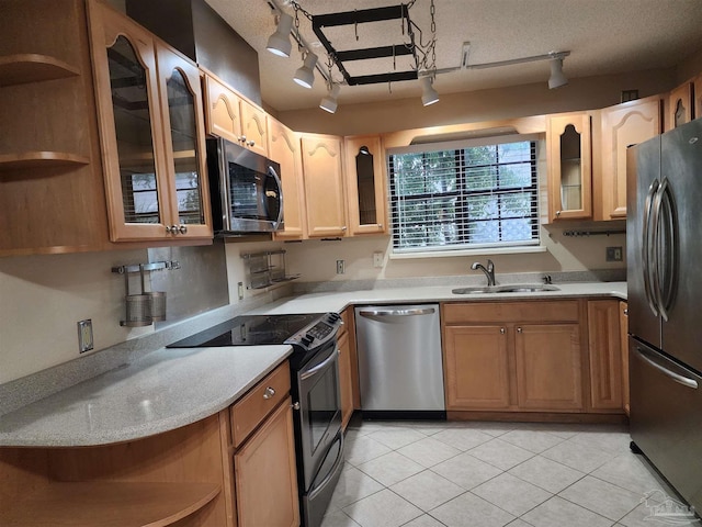 kitchen featuring sink, black appliances, rail lighting, light tile patterned floors, and a textured ceiling