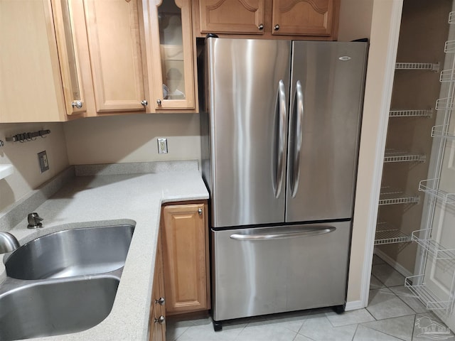 kitchen featuring sink, stainless steel refrigerator, and light tile patterned flooring