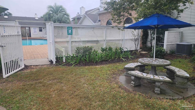 view of yard featuring a fenced in pool and central AC