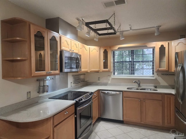 kitchen featuring stainless steel appliances, a textured ceiling, sink, rail lighting, and light tile patterned flooring