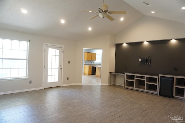 unfurnished living room featuring high vaulted ceiling, light hardwood / wood-style floors, and ceiling fan