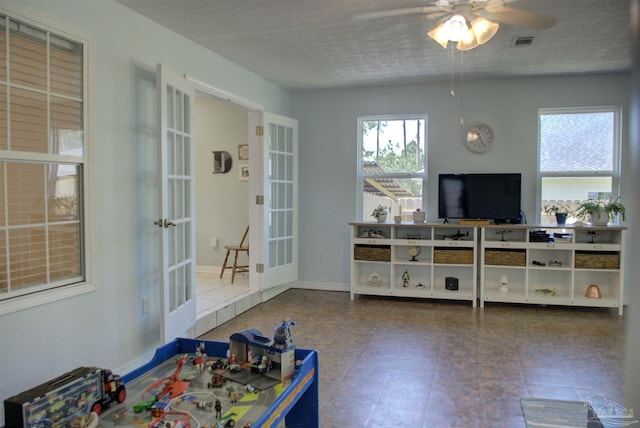 living room featuring ceiling fan and french doors