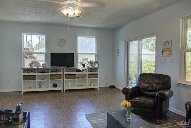 living room featuring a textured ceiling and ceiling fan