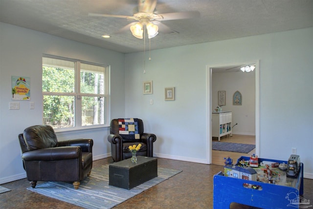 living area featuring a textured ceiling and ceiling fan