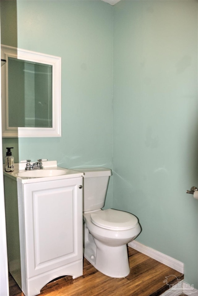 bathroom featuring vanity, hardwood / wood-style flooring, and toilet