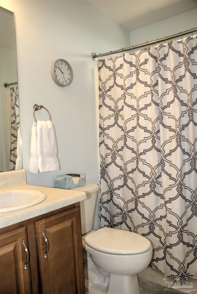 bathroom with vanity, curtained shower, and toilet