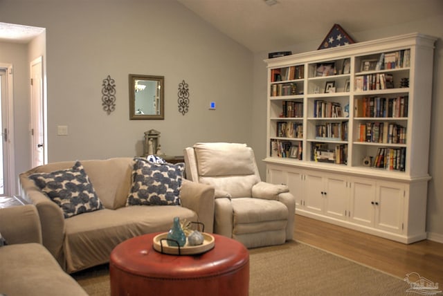 living room with hardwood / wood-style floors and vaulted ceiling