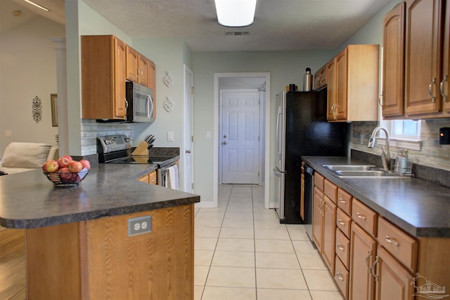 kitchen featuring backsplash, kitchen peninsula, sink, and appliances with stainless steel finishes