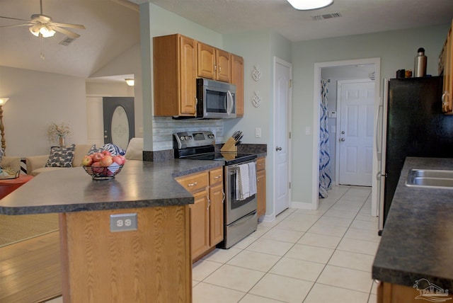 kitchen featuring vaulted ceiling, decorative backsplash, ceiling fan, light tile patterned floors, and appliances with stainless steel finishes