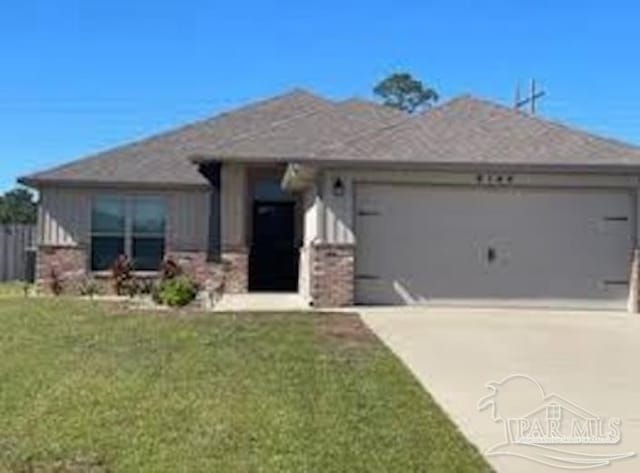 view of front facade featuring a garage, a front yard, and concrete driveway