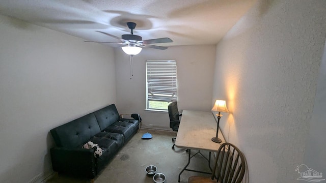 sitting room with a ceiling fan and a textured wall