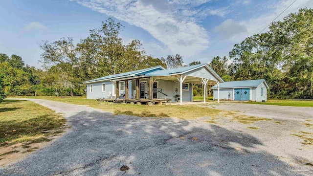 view of front facade featuring a porch, a front lawn, and an outdoor structure