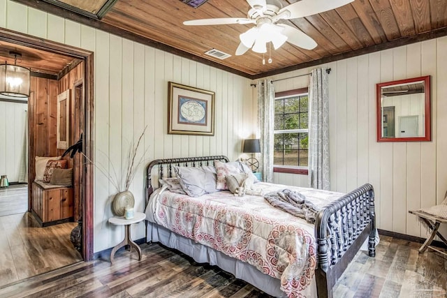 bedroom with ceiling fan, wooden walls, wood ceiling, and dark hardwood / wood-style floors