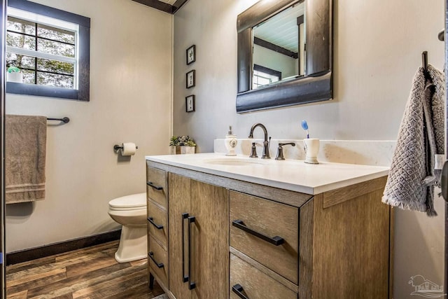 bathroom with hardwood / wood-style floors, vanity, and toilet