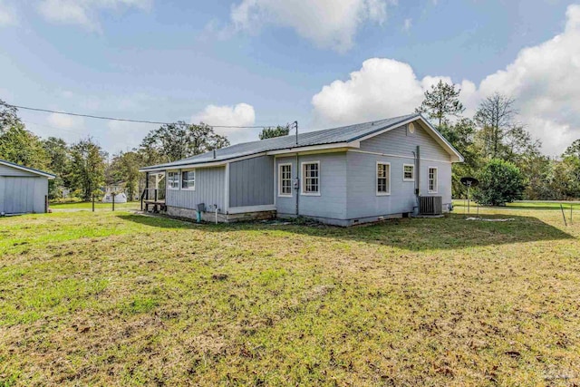 rear view of house with a lawn and cooling unit