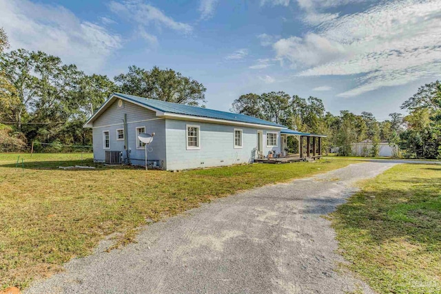 110 Glover Rd, Century, FL 32535 - view of front of house with central AC unit, gravel driveway, and metal roof