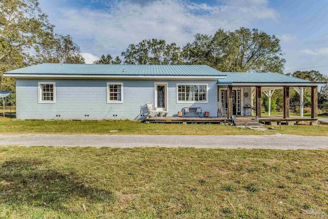 back of property featuring covered porch and a lawn