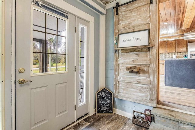 entryway featuring wood ceiling, a barn door, and dark wood-type flooring