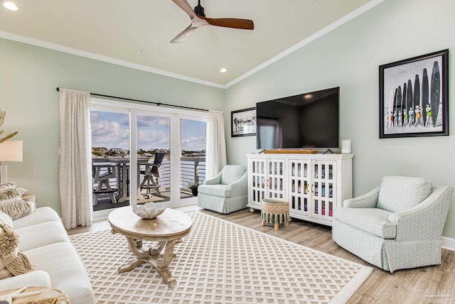 living area with lofted ceiling, ceiling fan, ornamental molding, and wood finished floors