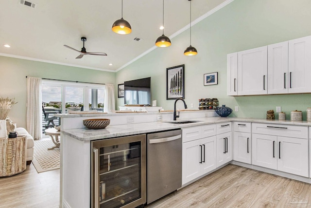 kitchen featuring crown molding, stainless steel dishwasher, a sink, beverage cooler, and a peninsula