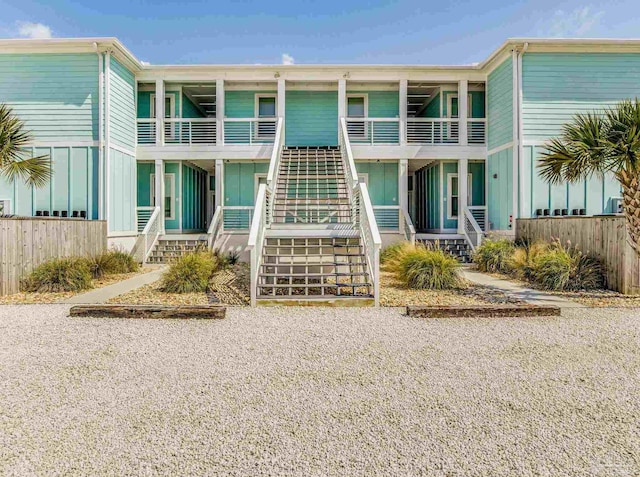 view of building exterior with stairs and fence