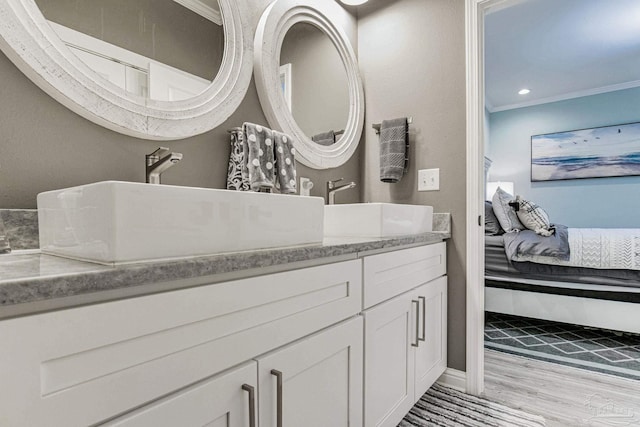 bathroom with ensuite bathroom, recessed lighting, wood finished floors, vanity, and crown molding