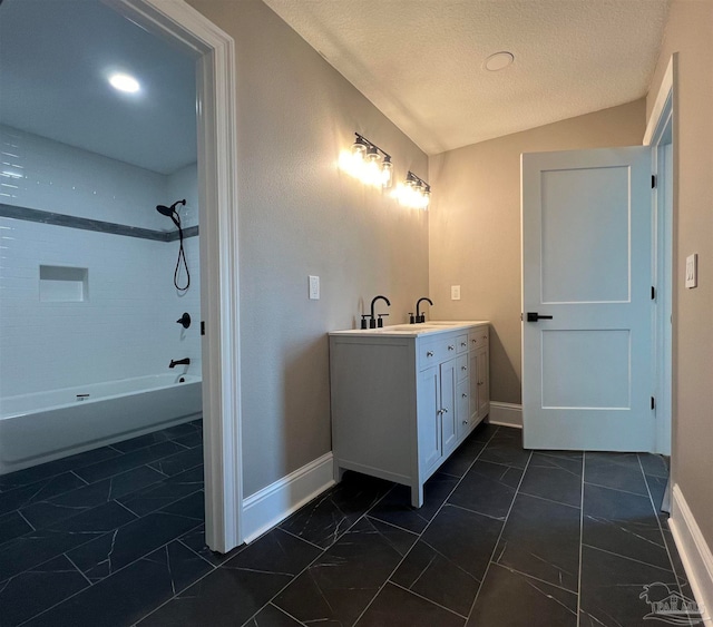 bathroom with a textured ceiling, vanity, lofted ceiling, and shower / washtub combination