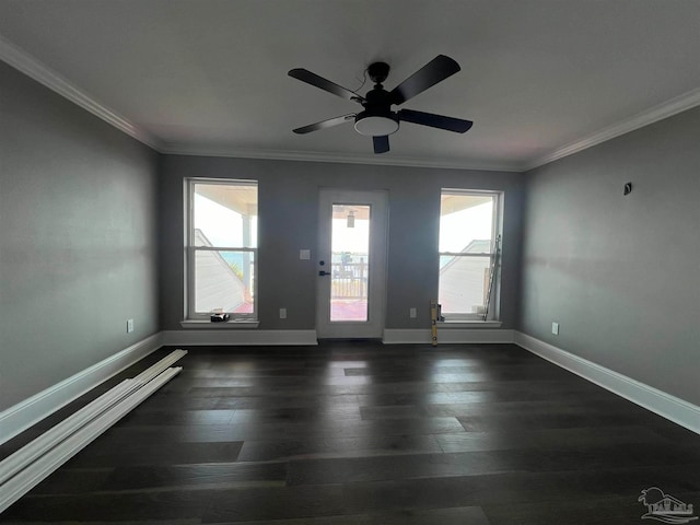 empty room with ornamental molding, dark hardwood / wood-style floors, and a healthy amount of sunlight