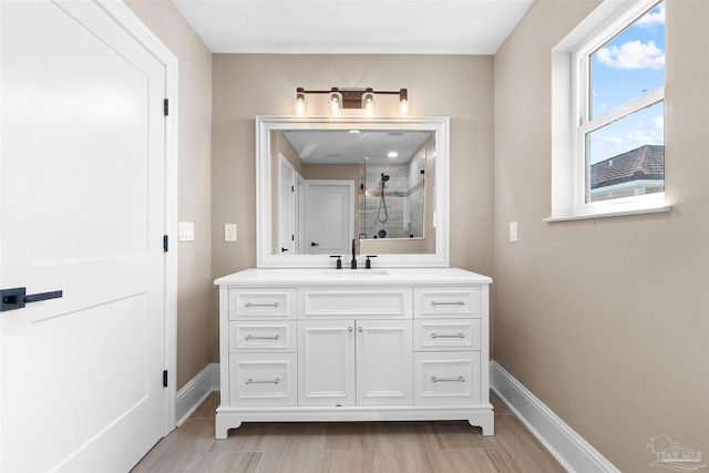 bathroom featuring tiled shower and vanity